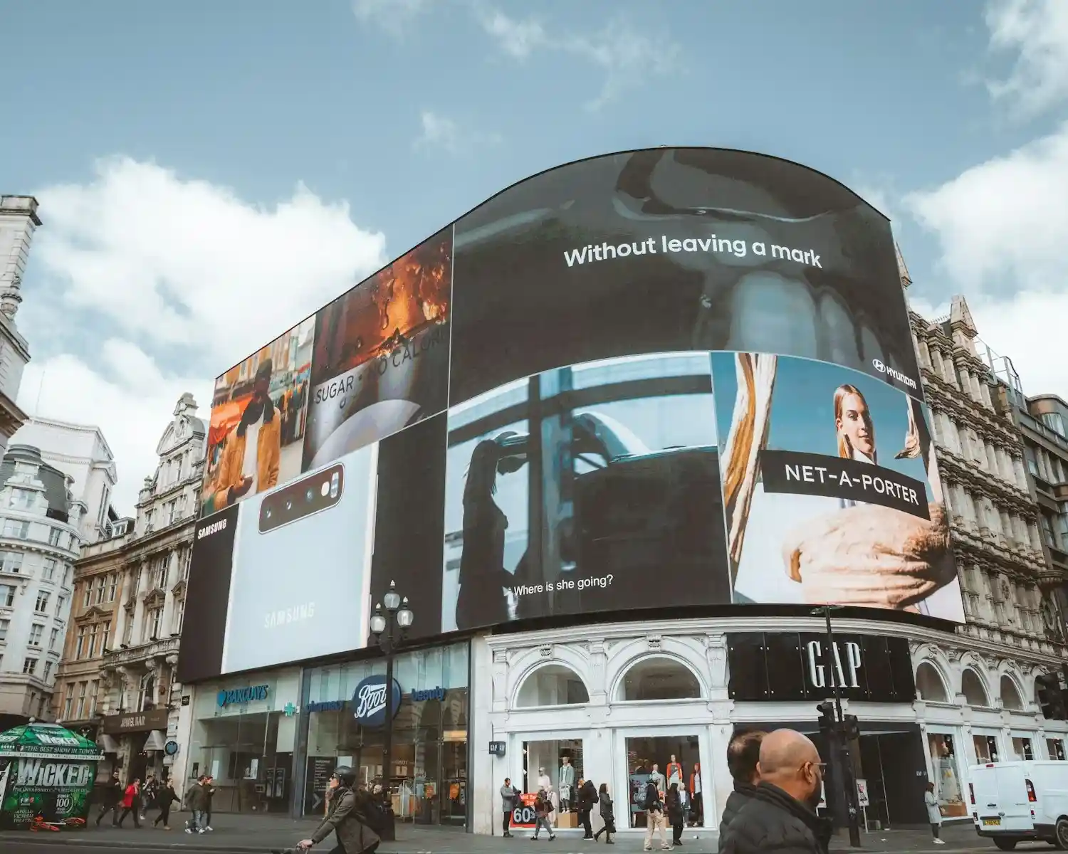 Large curved building with many digital billboards