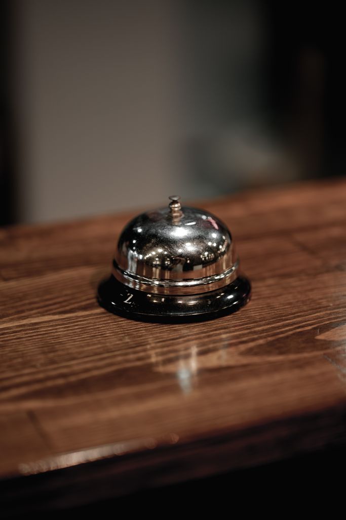 Worn brass service bell on a walnut desk, the kind of wake-up call most CRO programs need